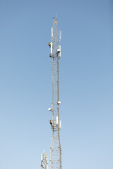 Obraz premium Mast or tower for mobile phone communication in bright sunshine and blue sky. Relay tower internet 4G