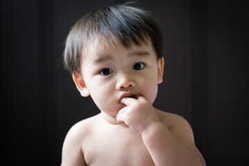 Asian baby sucking his finger