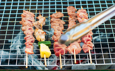 Close-up view of BBQ meat being grilled over the charcoal.