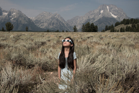 Teenage girl watching total solar eclipse in Grand Teton National Park