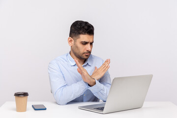 This is the end! Strict male boss sitting office workplace, crossing hands showing x sign stop gesture to laptop screen, finishing video call, warning of troubles. indoor studio shot, white background