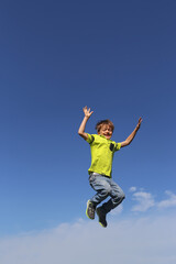 Fototapeta na wymiar Junge springt in die Luft, im Hintergrund blauer Himmel