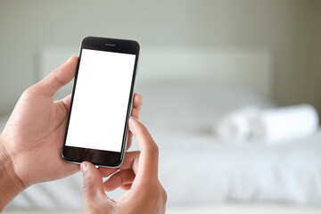 Close up of a man hand holding the black smart phone with white screen and blurred background.