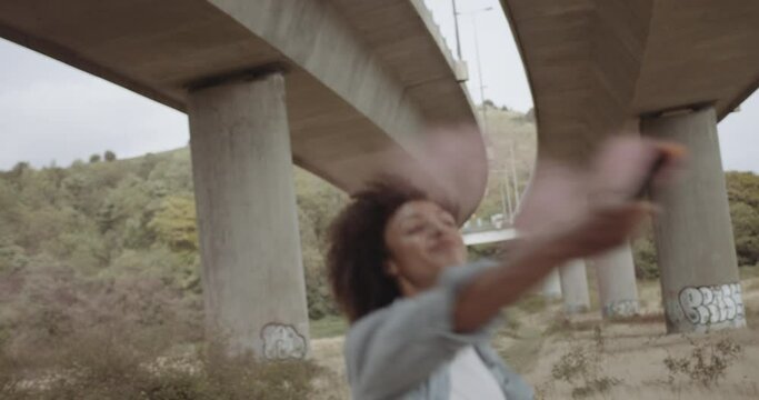 Black afro woman protestor holding red smoke bomb in urban city outdoors