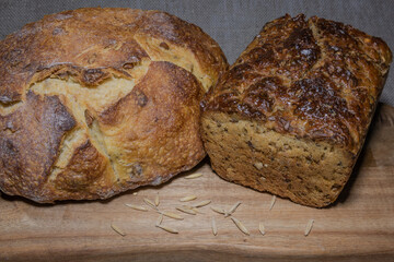 Two types of multigrain bread on a wooden kitchen board. Pumpkin and rye bread. Healthy foods