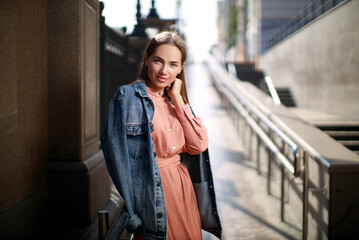 Fototapeta premium Beautiful young woman wearing dress and posing on the city street