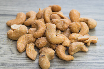 Heap of salted roasted cashew nuts on the wooden table