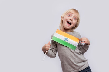 Happy boy holding flag of India and makes funny faces. Learning hindi