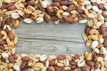 Penuts,cashews,almons,pistachios roasted and salted mixed together - with copy space.