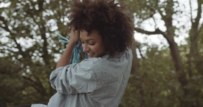 Female on swing in forrest together with friend playing carefree
