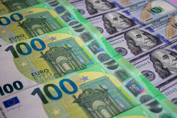 Obraz na płótnie Canvas One hundred US dollars and 100 new Euros banknotes. Macro. Color image of money