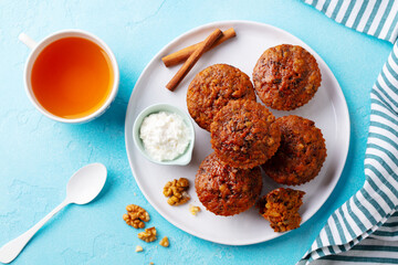 Healthy vegan carrot muffins with ricotta cheese and cup of tea. Blue stone background. Top view.