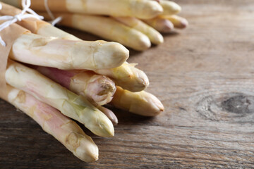 Bunch of fresh white asparagus on wooden table, closeup. Space for text