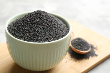 Poppy seeds in white ceramic bowl on table