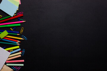 School supplies and stationery on black school chalk board