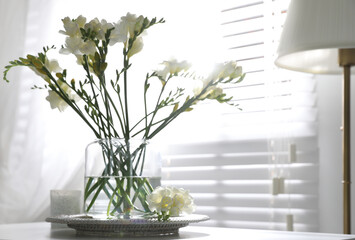 Beautiful spring freesia flowers on table in room