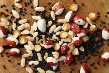 Mixed vegetable seeds on wooden background, flat lay