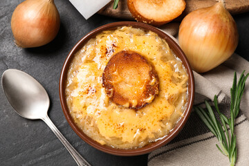 Tasty homemade french onion soup served on black table, flat lay