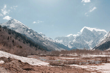 mountain landscape with snowy peaks and a valley on a Sunny