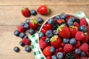 Mix of ripe berries on wooden table, flat lay