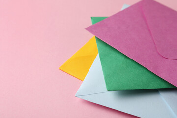 Colorful paper envelopes on pink background, closeup. Space for text