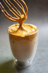 Dalgona Coffee; fluffy whipped coffee on milk. Coffee is a beverage made by whipping equal proportions of instant coffee, sugar and hot water until it becomes creamy and adding it to cold or hot. 