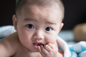 Asian baby sucking his finger