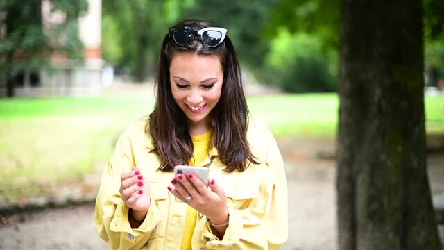 Happy girl using a smart phone in summer in a park