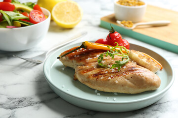 Tasty grilled chicken fillets with arugula and salt on white marble table, closeup