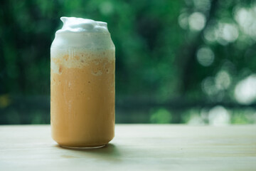 Thai iced milk tea with milk froth on top.