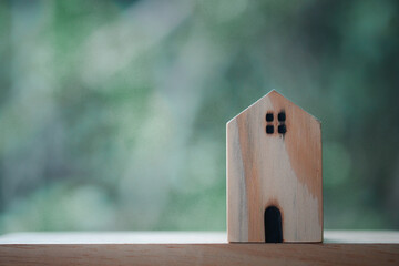 Obraz na płótnie Canvas Miniature house on wood table with green nature background.