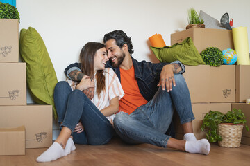 Happy young couple moving in new home first time - Man and woman having fun unpacking carton box in new property house - Change apartment day and people lifestyle relationship concept