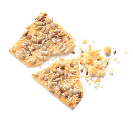 Broken delicious crispy cracker with seeds on white background, top view