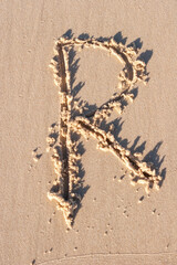 R - Alphabet letter written on sand 