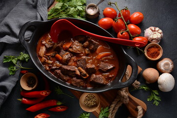 Beef Bourguignon in a pan. Stew with red wine ,carrots, onions, garlic, a bouquet garni, and garnished with pearl onions, mushrooms and bacon. French cuisine- regional recipe from Burgundy