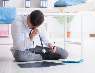 Doctor sitting on the floor in hospital