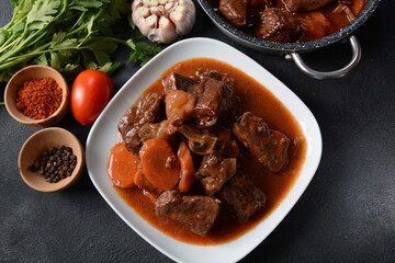 Beef Bourguignon in a pan. Stew with red wine ,carrots, onions, garlic, a bouquet garni, and garnished with pearl onions, mushrooms and bacon. French cuisine- regional recipe from Burgundy