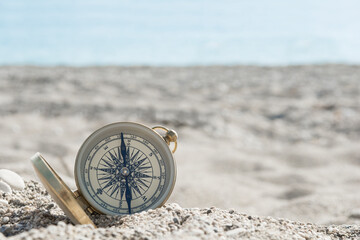 Old compass on the beach, close up - obrazy, fototapety, plakaty