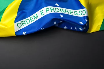 Fotobehang Braziliaanse vlag liggend op zwarte korrelige achtergrond © respiro888