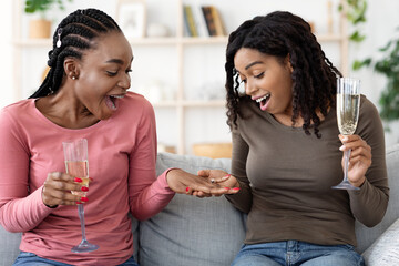 Black woman happy to see her friends engagement ring