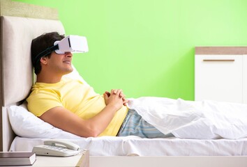 Young man with virtual glasses in the bedroom