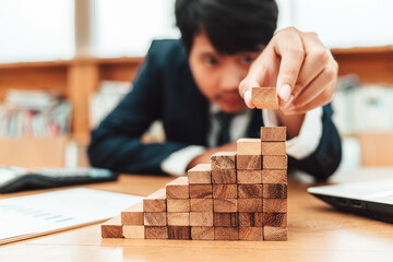 Ant eye view Male hand stacking wooden blocks. Business development and growth concept