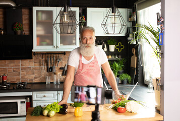 Bearded senior Man preparing vegetables to make a plate of food confined by covid-19.