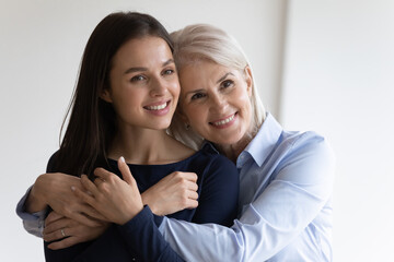 Smiling middle-aged mother hug comfort millennial daughter, show love and care in relationship....