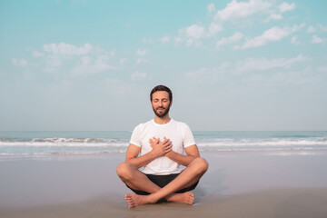 the guy sits on the seashore in the lotus position and meditates.