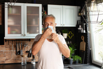 Elderly caucasian man wearing protective face mask at home.