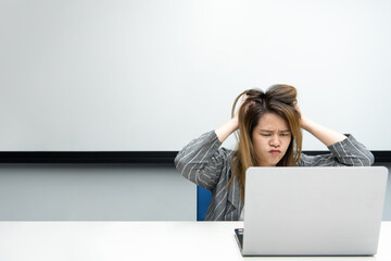 Woman working by laptop in office with annoyed