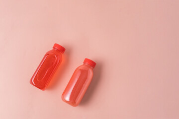 The healthy fruit drink in Eco bottles on pink background. Minimal style. Zero waste.