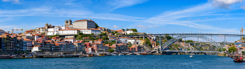 Fototapeta na wymiar Panorama of the riverbank of Ribeira District and Dom Luis I Bridge in Porto, Portugal