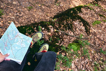 Hiking boots in outdoor action. Top View of Boot on the trail. Close-up Legs In Jeans And sport trekking shoes on rocky srones of Mountain river waterfall.